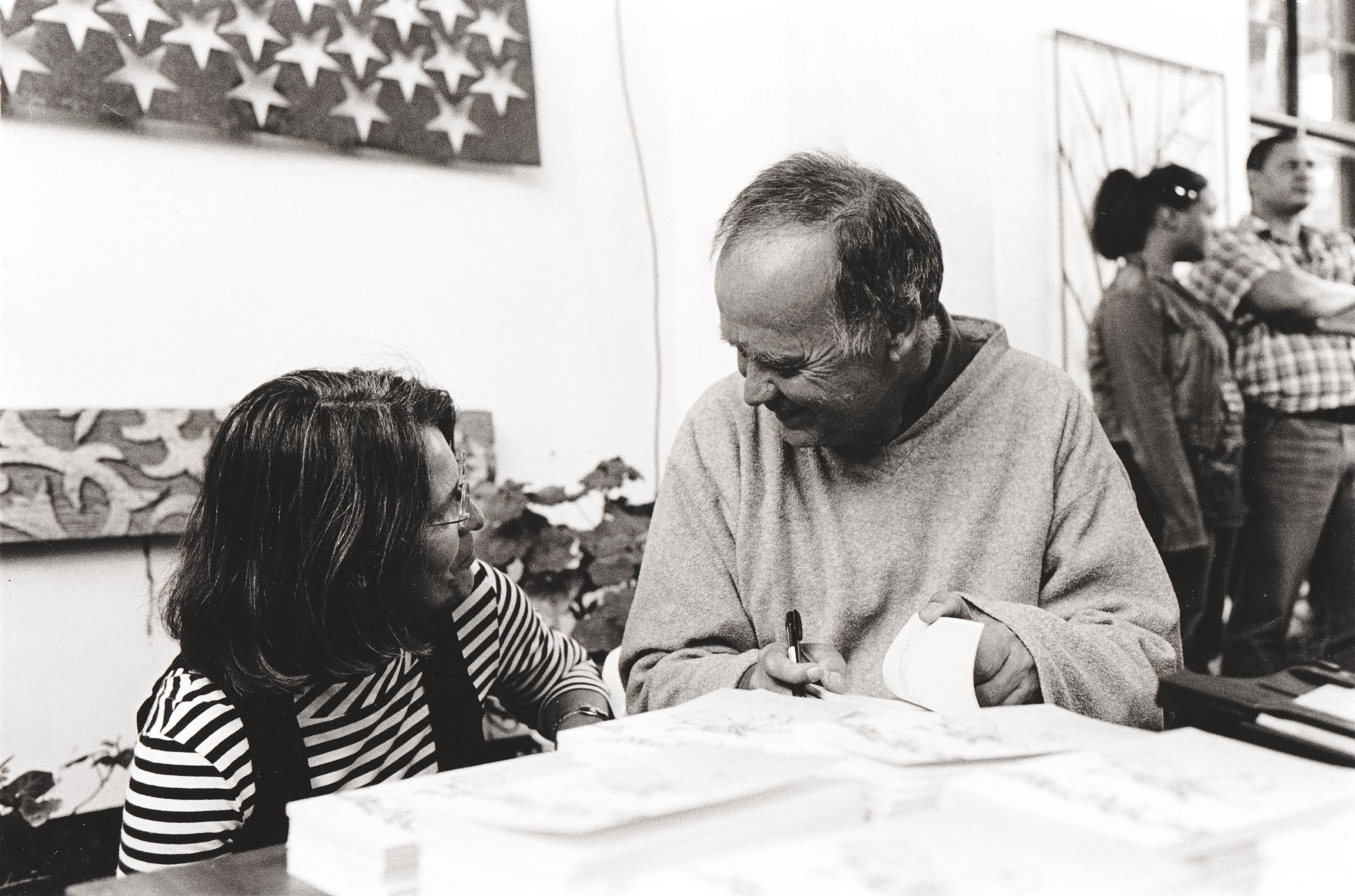 Two people talking around a table.