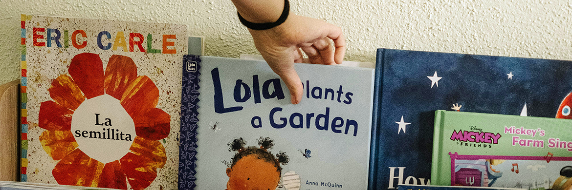 someone selected a picture book from a children's book display