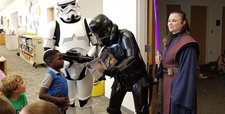 People dressed as Star Wars characters and talking to children