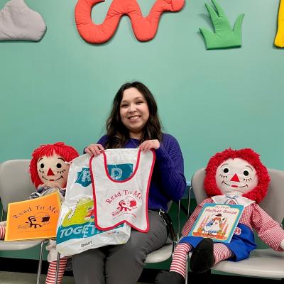 Library staff member Jacqui V. displays items in the Baby Book Bags.