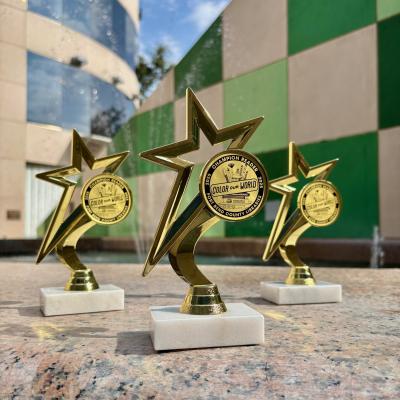 3 trophies are displayed in front of a colorful background