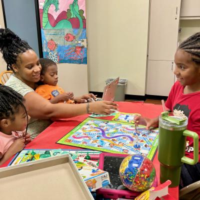Johnson Family playing a board game at George Memorial Library Game Room