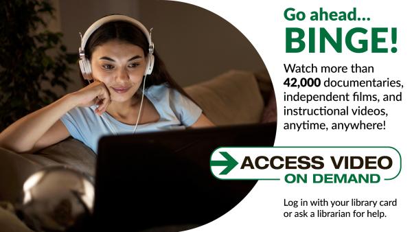 Girl with headphones is watching a video monitor.