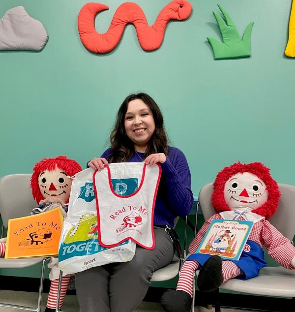Library staff member Jacqui V. displays items in the Baby Book Bags.