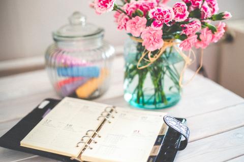 artful photo of planner and vase of flowers
