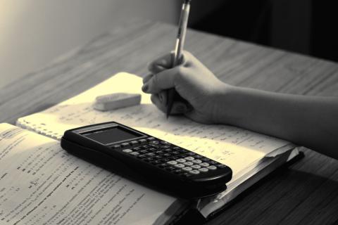 arm with pencil doing homework 