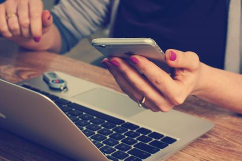 person using laptop and mobile phone