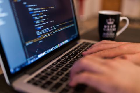 person coding on a laptop computer