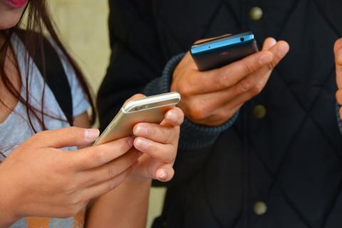 close up of two people using smartphones