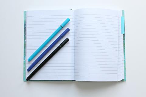 Three pens on a blank notebook