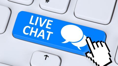 Closeup on a keyboard with a big blue key that says "Live Chat" on it, with chat bubble icons.  A hand curser symbol hovers over it.