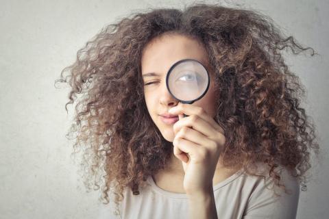Girl looking through a magnifying glass