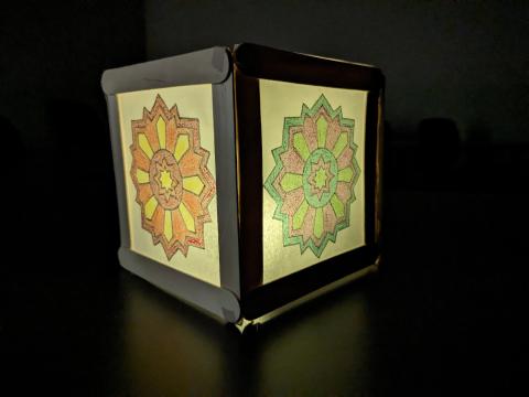 paper lantern in dark room glowing softly with mandala designs
