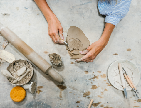 Person creating design in clay