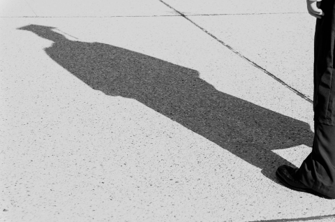 Shadow of person wearing cap and gown