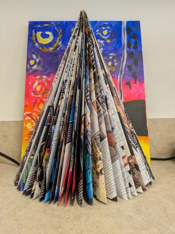 cone shaped tree made out of a folded magazine with a brightly colored background
