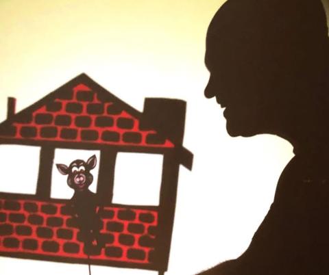 man's shadow with brick house and pig shadow puppet