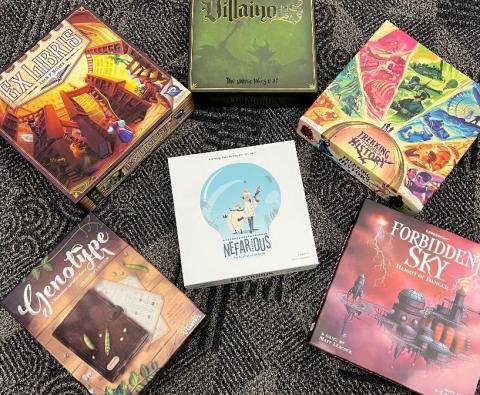 photo of five board game boxes encircling a sixth board game box on the floor