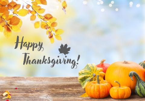 Happy Thanksgiving, flanked by autumn leaves and gourds