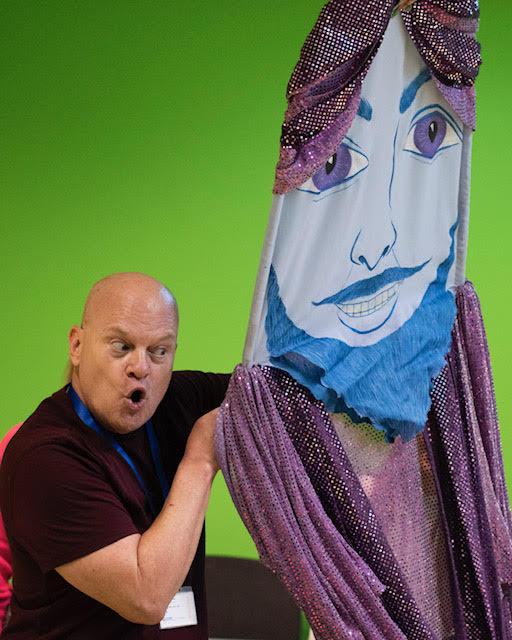 Man holding a large puppet with a face