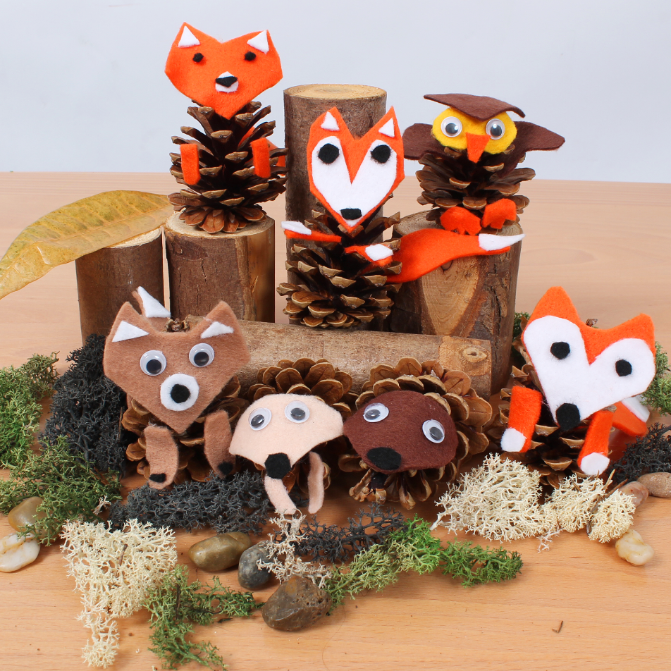 Image of several forest creatures made from pinecones posed on fake logs and foliage 