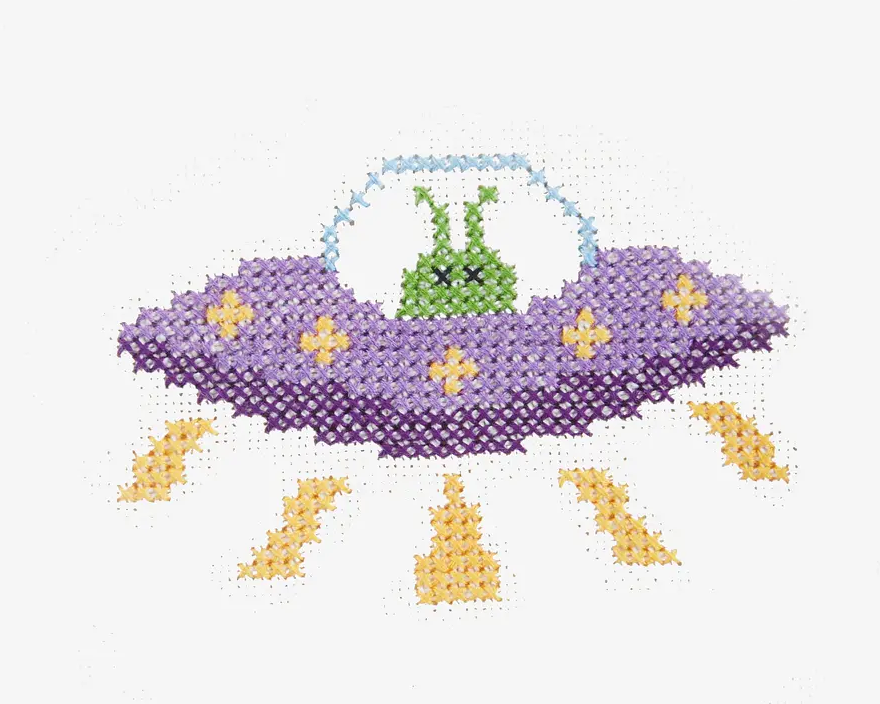 purple space ship with green alien made in cross stitch