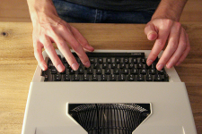 Person typing on typewriter