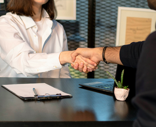 Woman shaking a man's hand after what appears to be a job interview