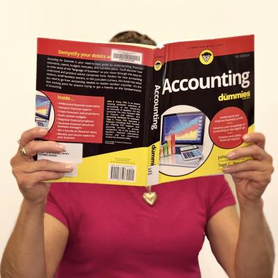 Janie Garza holding up the book "Accounting for Dummies"