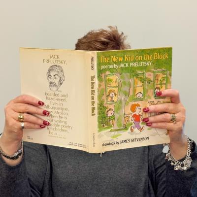 Jill Sumpter holding up the book "The New Kid on the Block" by Jack Prelutsky